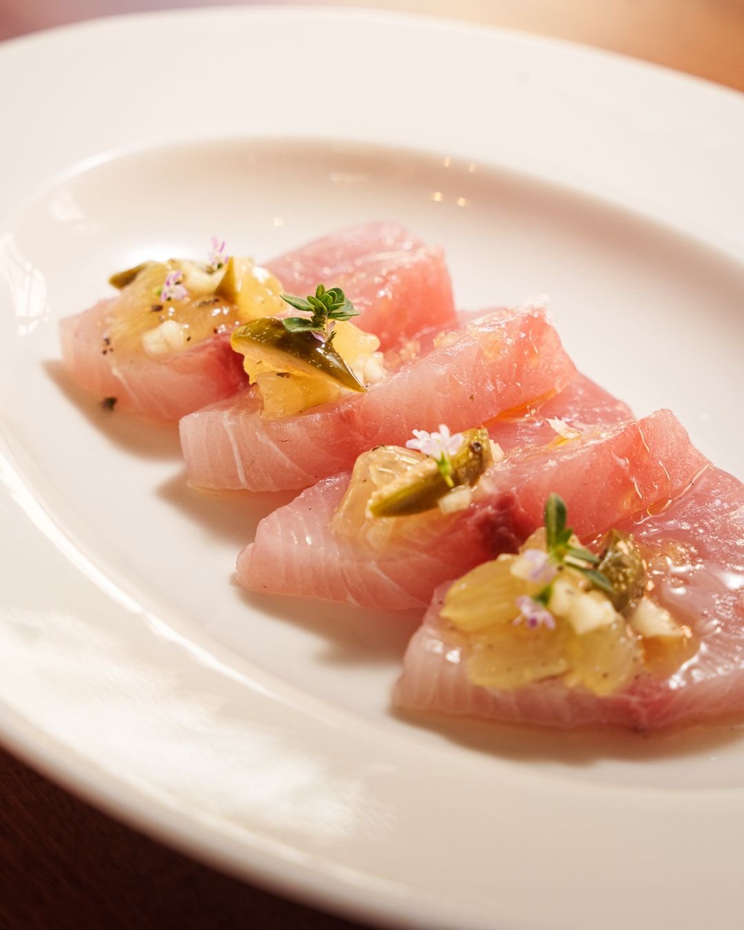 Fette di pesce crudo con erbette e fiori
