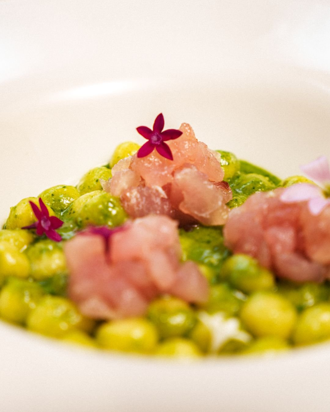 Tartare rosa su piselli verdi, con fiori